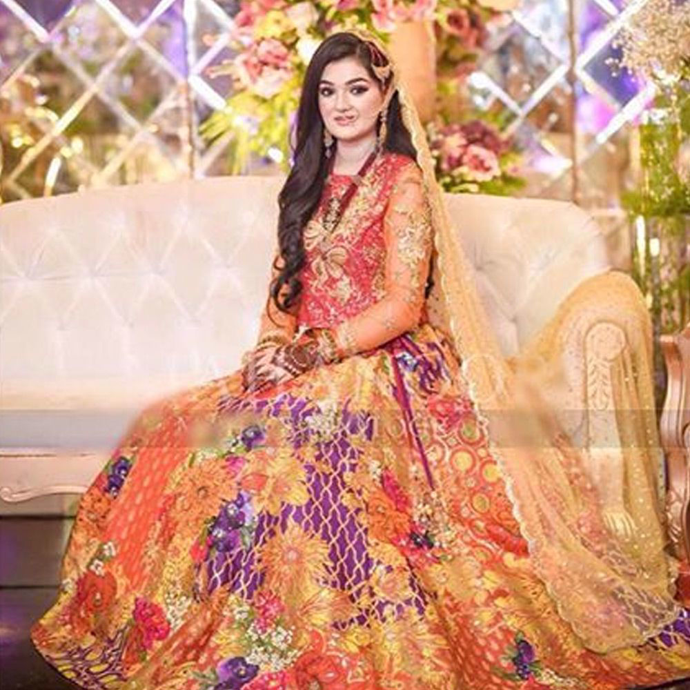 Picture of Our beautiful client Rida Shafqat sparkles in a custom made mehndi bridal that blends together vibrant hues of rust, orange and coral.
